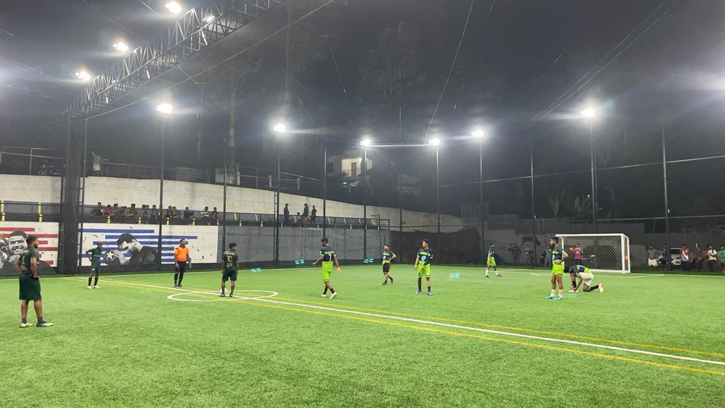 Evening football match under floodlights at Joyous Sports Arena, Chingavanam